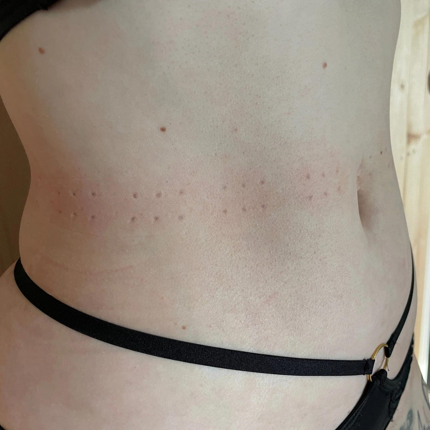 De afdrukken op de middel van een persoon, afkomstig van een lederen band met spikes voor BDSM