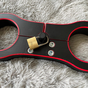 Detailfoto van een schandpaal voor BDSM in het zwart met rode accenten