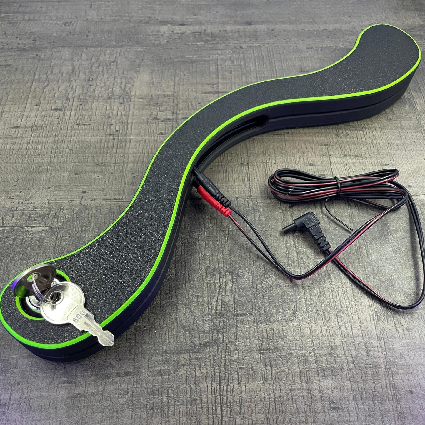 Een BDSM humbler met e-stim functionaliteit in het zwart met UV-gele accenten