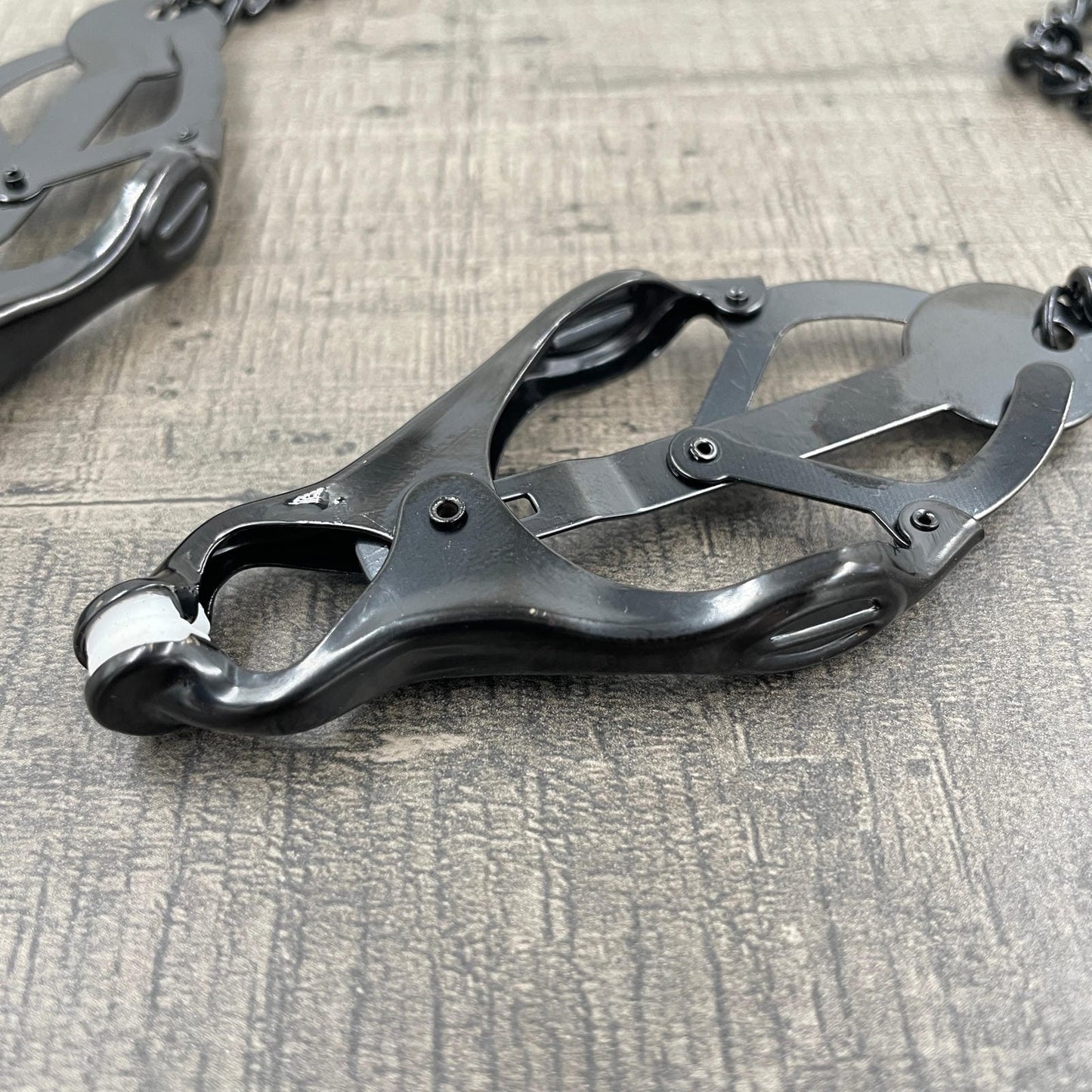 Een set zwarte clover-clamps tepelklemmen met een ketting