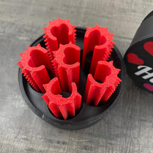 Een set van zes rode shibari rope spikes in een doosje