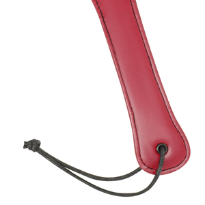Detail shot of a vegan leather paddle for BDSM in red