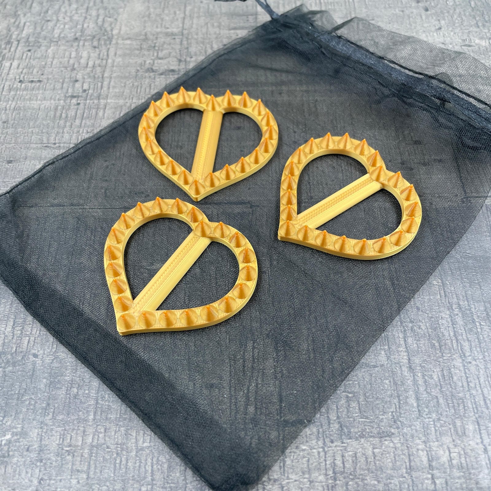 Drie hartvormige shibari rope spikes in de kleur goud
