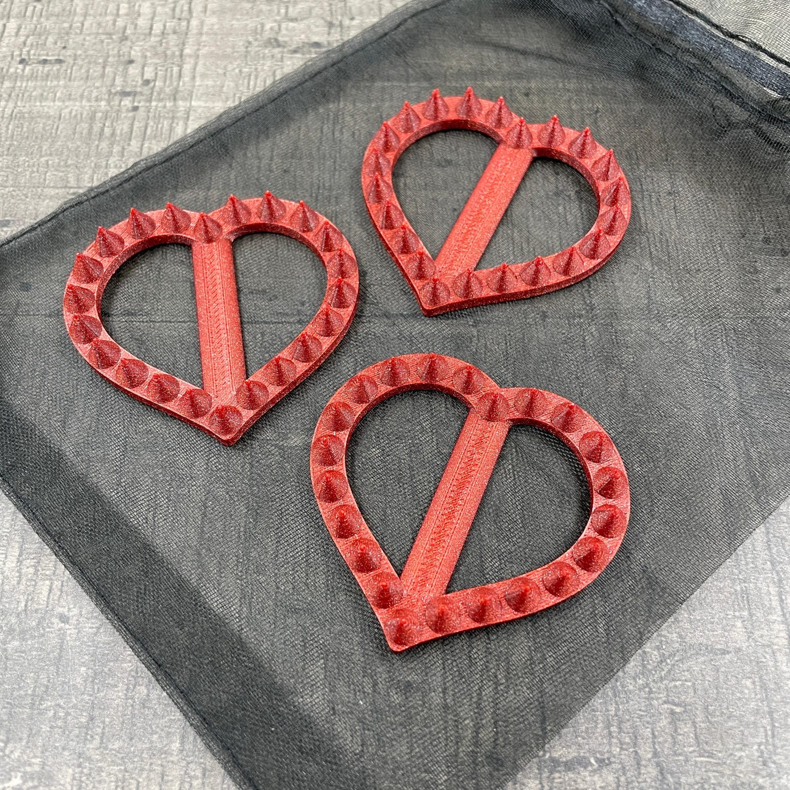 Drie hartvormige shibari rope spikes in de kleur rood met glitter