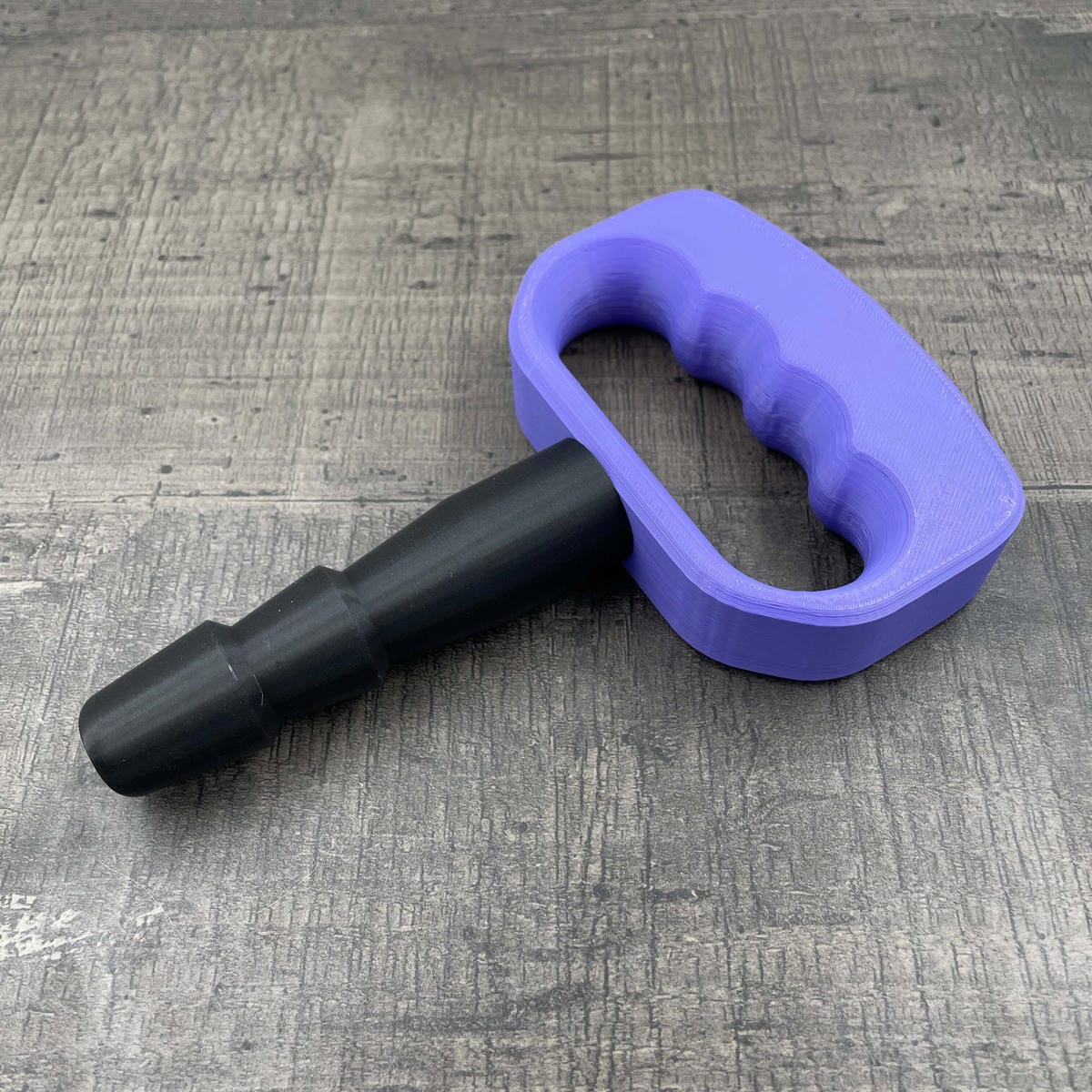 Een adapter voor vac-u-lock seks toys met een paarse handgreep.