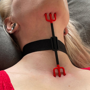 De hals van een persoon met een BDSM heretic's fork in rood en zwart