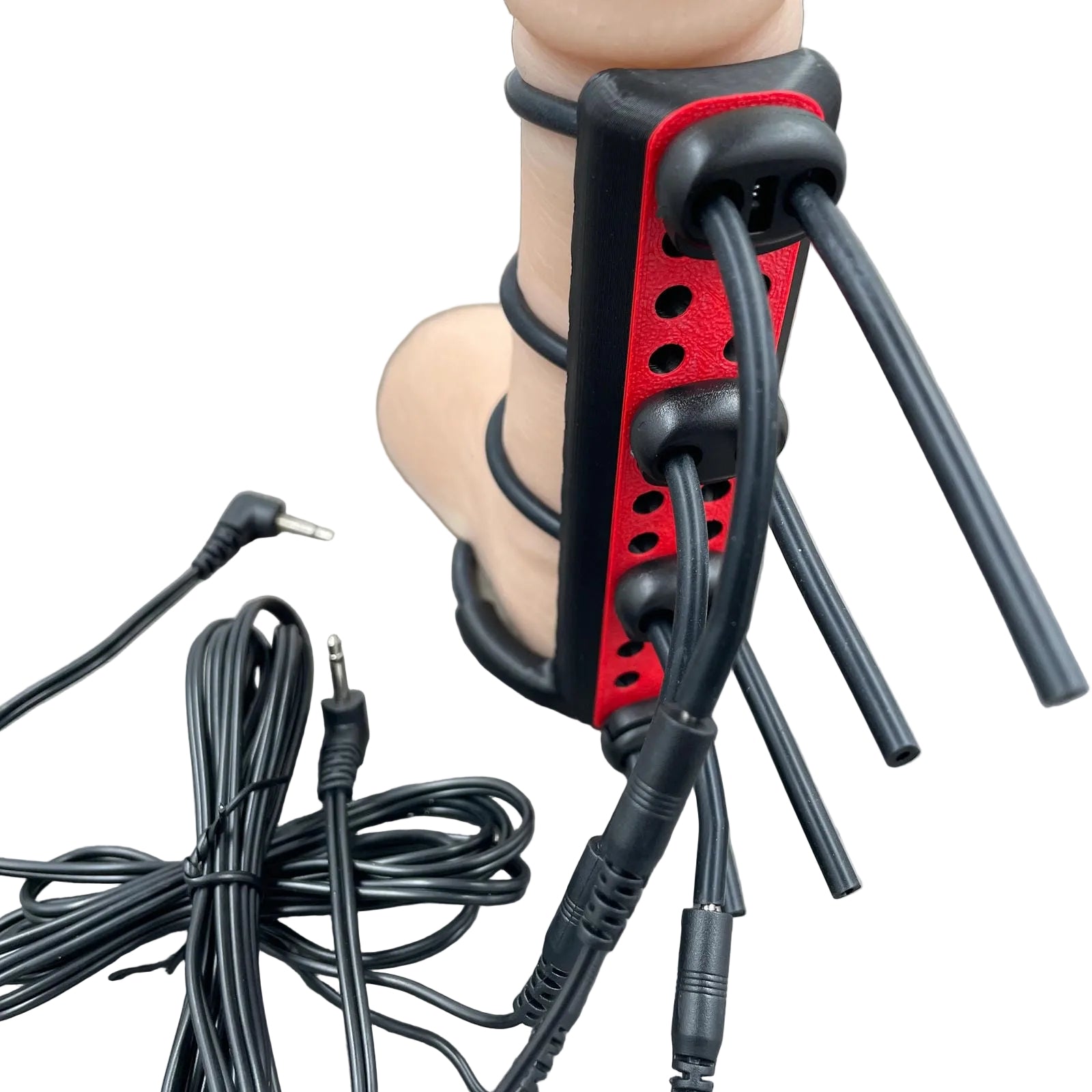 Een e-stim BDSM toy voor de penis met straps - met kabels en een dildo als voorbeeld