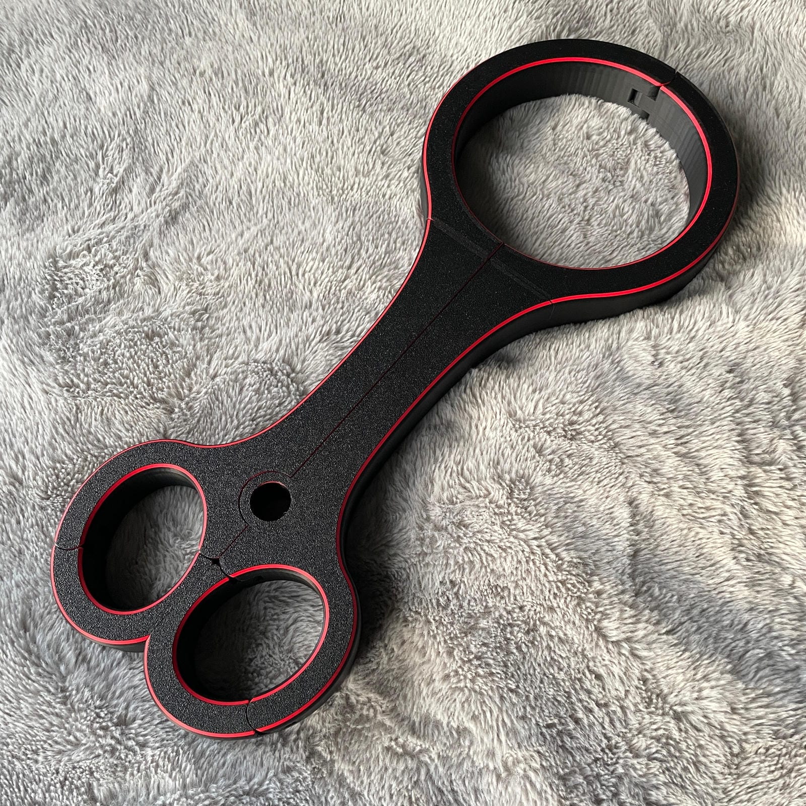 Een BDSM rigid fiddle in het zwart met rode accenten