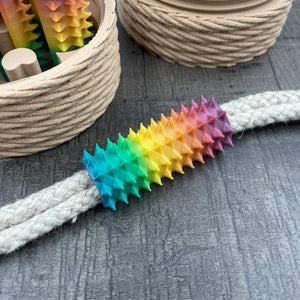 Een shibari rope spike in regenboogkleuren van 3DSM op een stuk touw