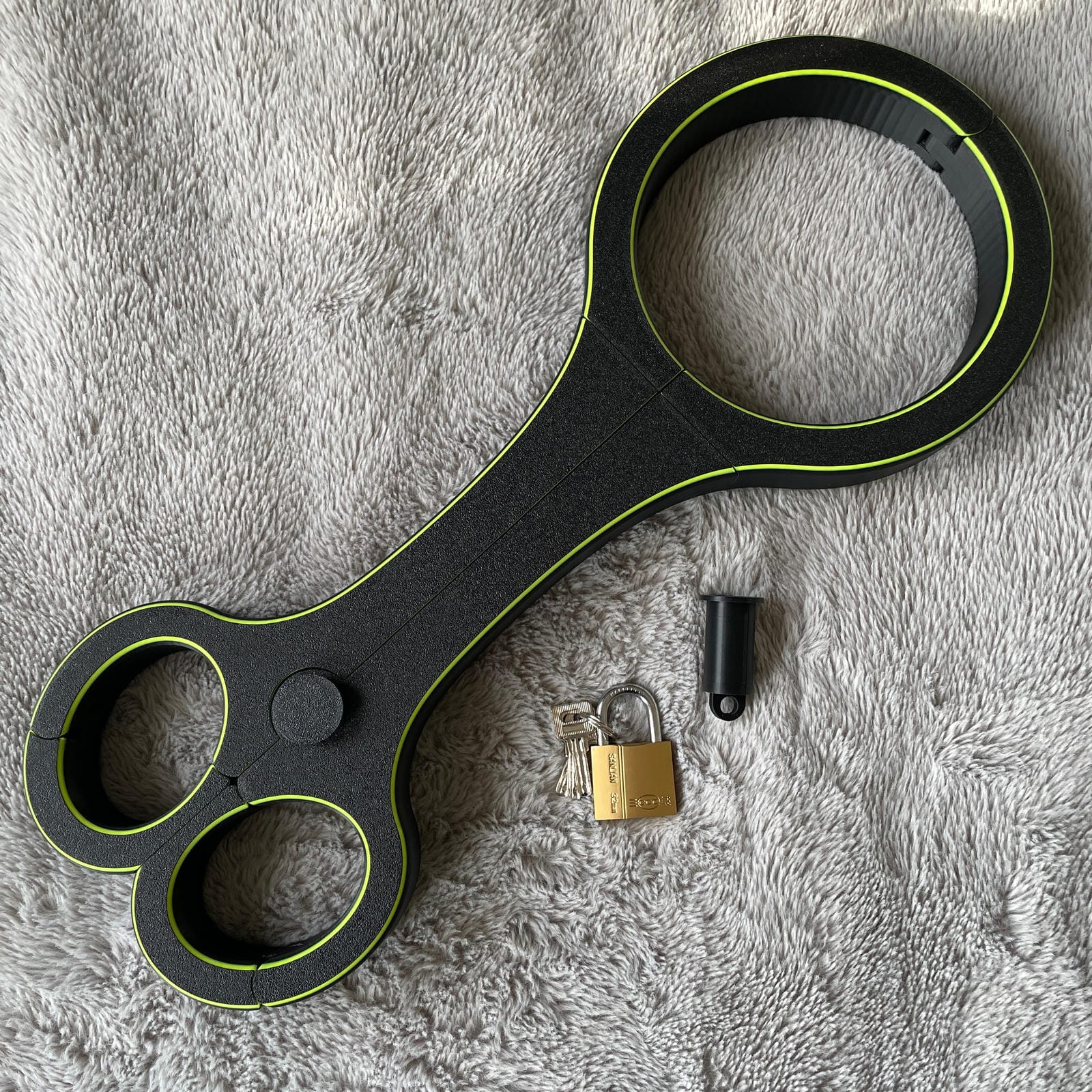 Een BDSM rigid fiddle in het zwart met UV-gele accenten