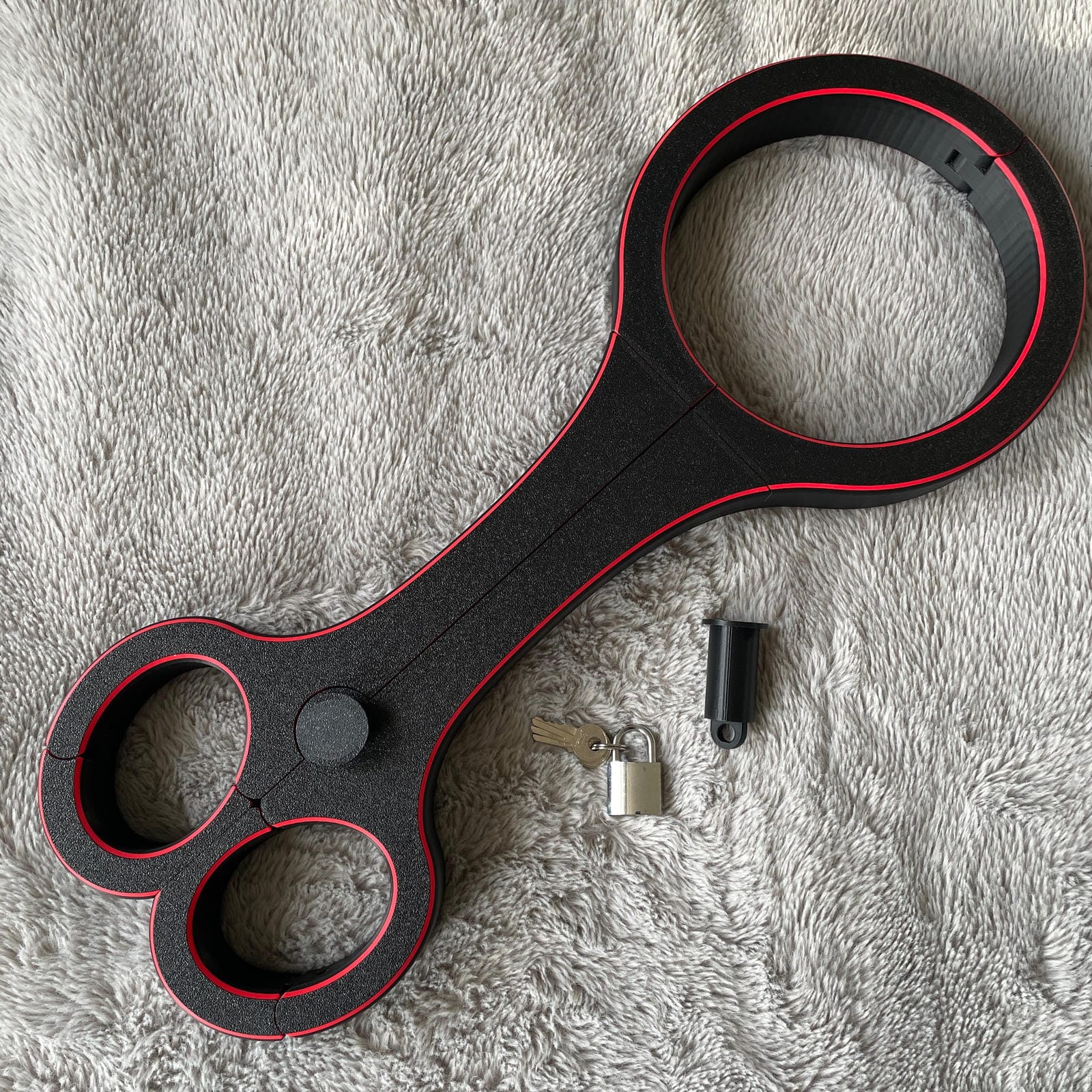 Een BDSM rigid fiddle in het zwart met rode accenten