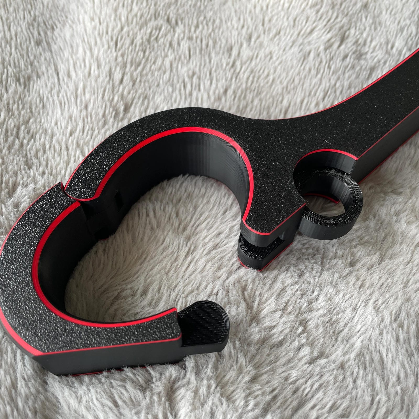 Detailfoto van de polsen van een BDSM rigid fiddle in het zwart met rode accenten