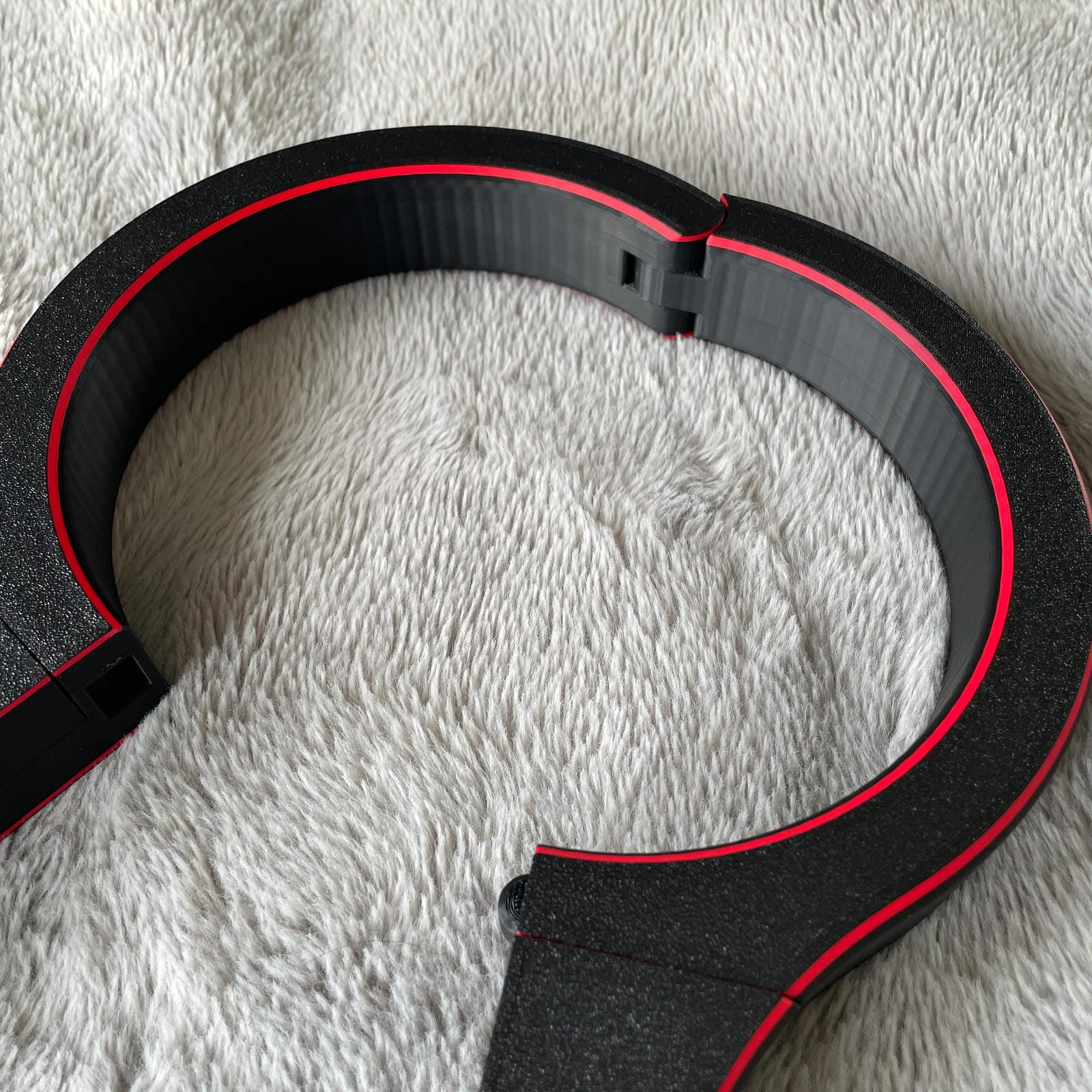 Detailfoto van de nek van een BDSM rigid fiddle in het zwart met rode accenten