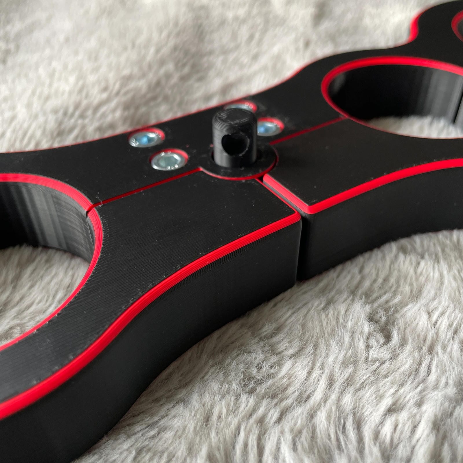 Detailfoto van een schandpaal voor BDSM in het zwart met rode accenten