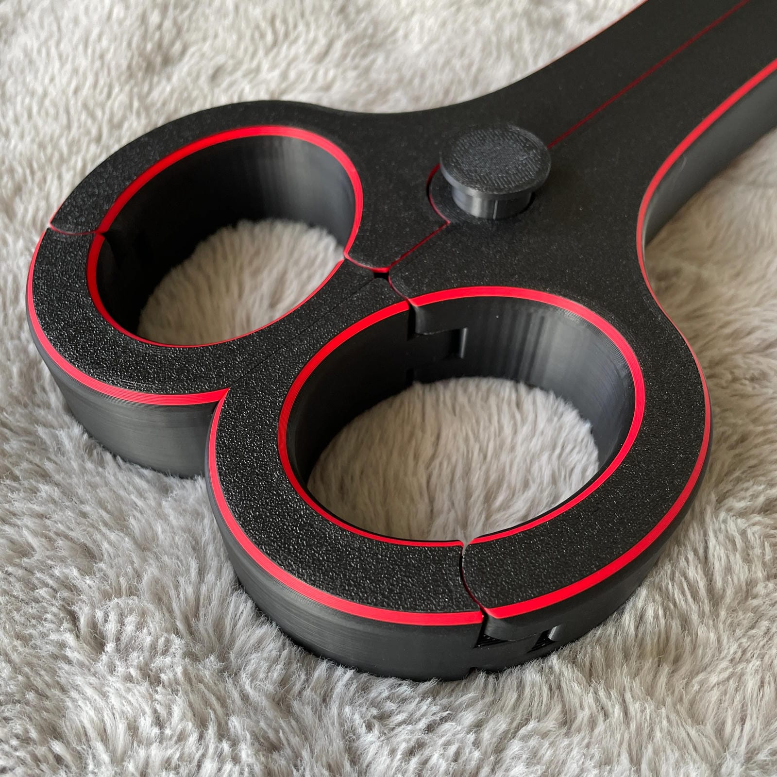 Detailfoto van de polsen van een BDSM rigid fiddle in het zwart met rode accenten