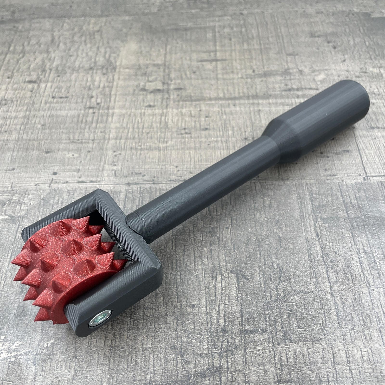 Een BDSM pinwheel met een zwart handvat en een rood wieltje