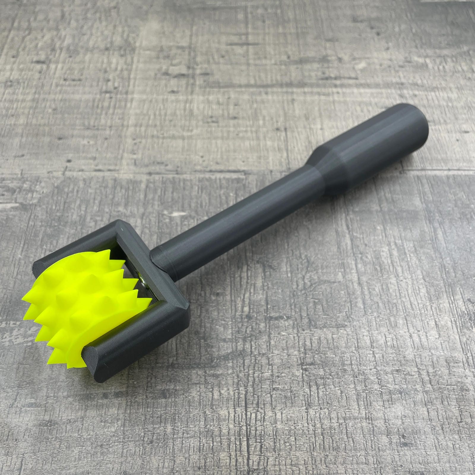 Een BDSM pinwheel met een zwart handvat en een geel wieltje