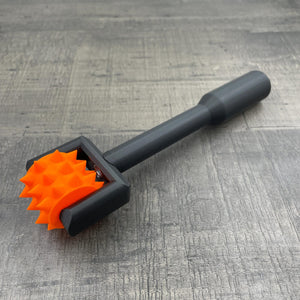 Een BDSM pinwheel met een zwart handvat en een oranje wieltje