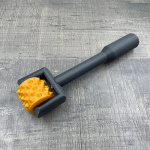 Een BDSM pinwheel met een zwart handvat en een goudkleurig wieltje