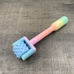 Een BDSM pinwheel met een pastel-kleurig regenboog handvat en een blauw wieltje