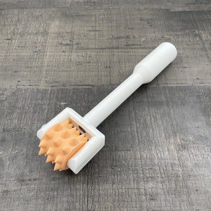 Een BDSM pinwheel met een wit handvat en een oranje wieltje