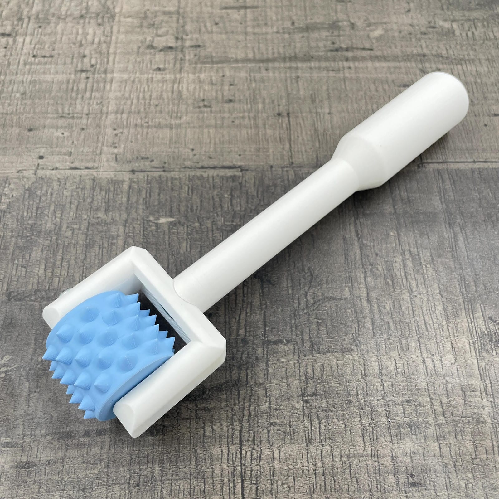 Een BDSM pinwheel met een wit handvat en een blauw wieltje