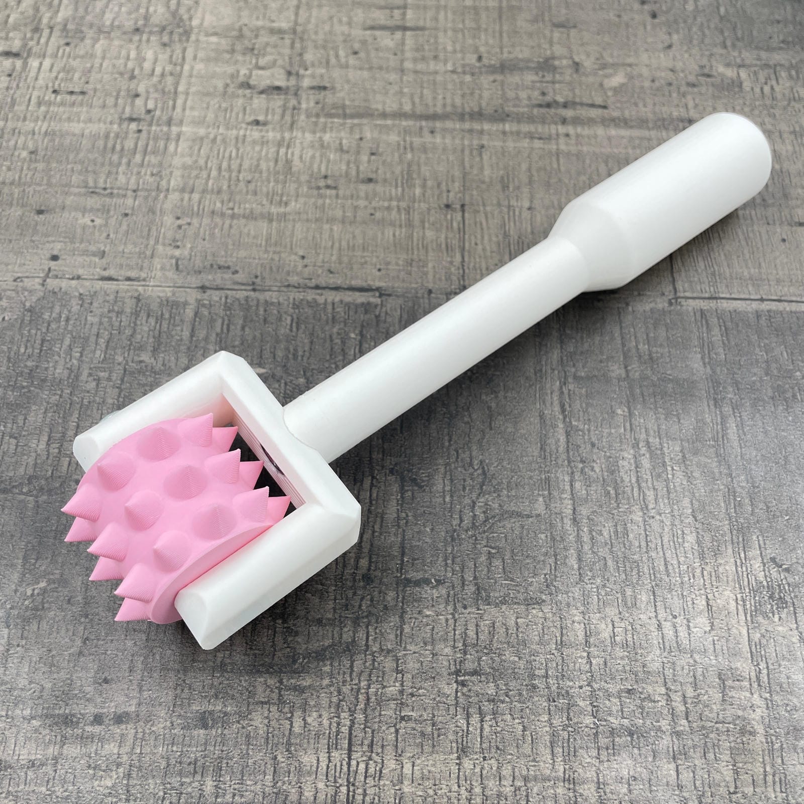 Een BDSM pinwheel met een wit handvat en een roze wieltje