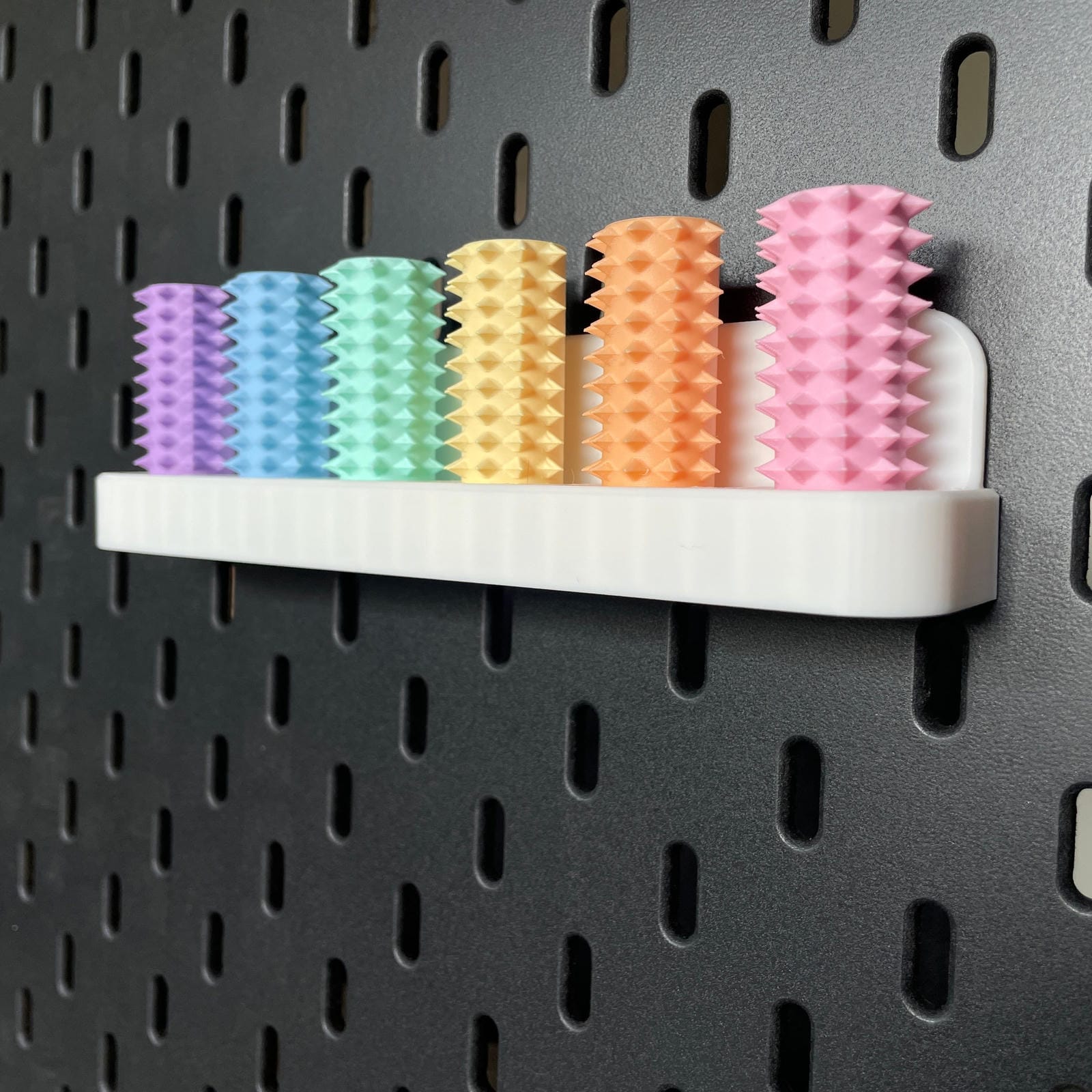 Een doosje met zes shibari rope spikes in regenboog kleuren voor de Ikea Skadis