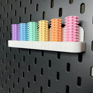 Een doosje met zes shibari rope spikes in regenboog kleuren voor de Ikea Skadis