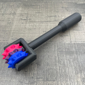 Een BDSM pinwheel met een zwart handvat en wieltje in de kleuren van bi-seksuele vlag
