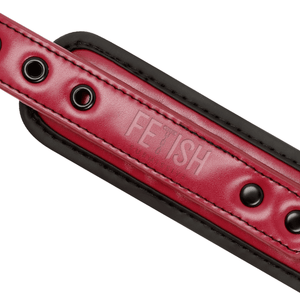 Detail shot of a BDSM collar with leash made from vegan leather in red and black colour